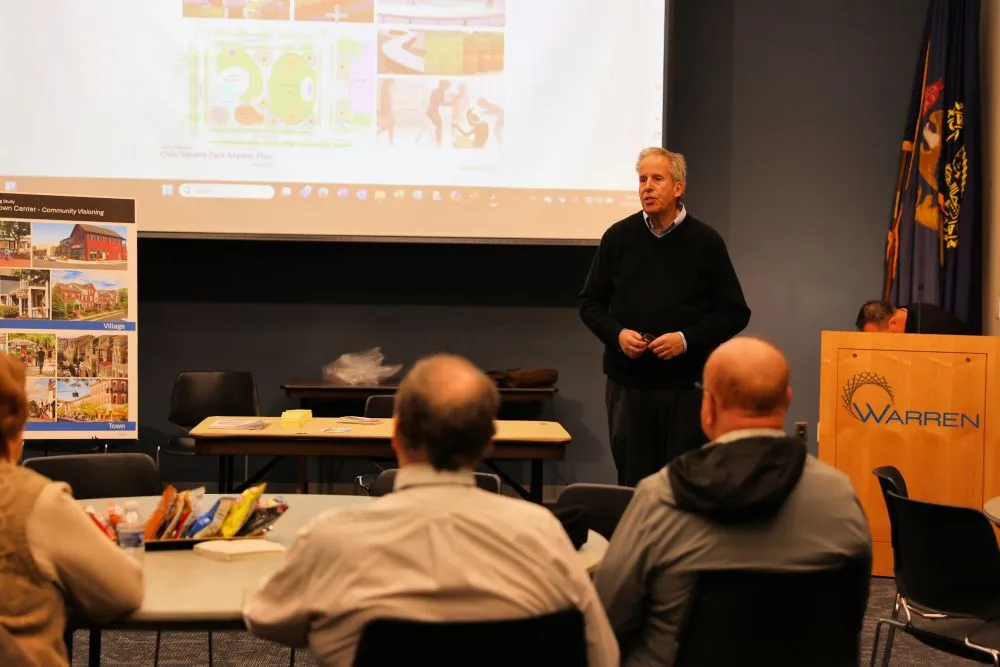 a man giving a presentation in front of a screen to an audience