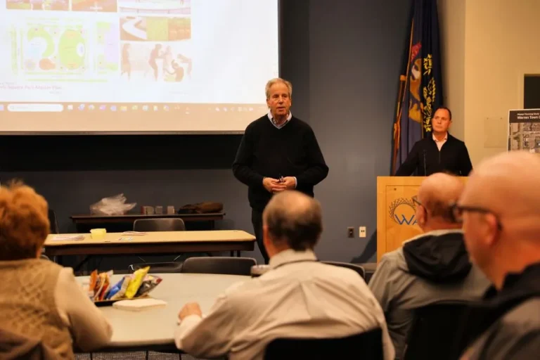 a man giving a presentation in front of a screen to an audience