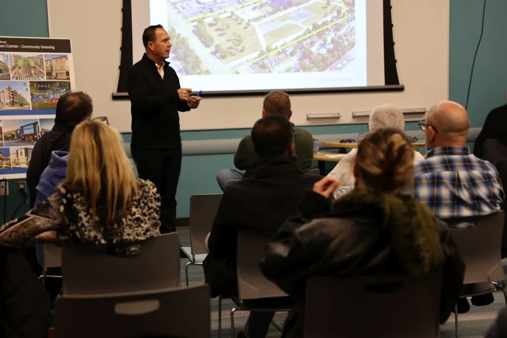 a man giving a presentation to an audience in front of a screen